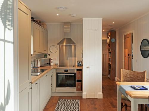 a kitchen with white cabinets and a stove top oven at Hona in Mangersta