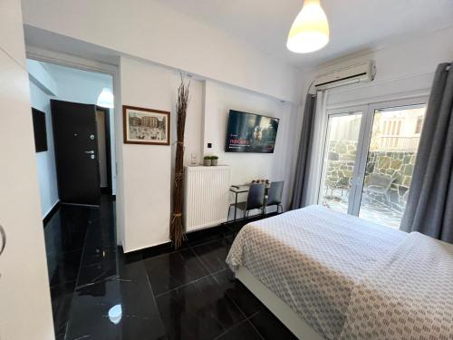 a bedroom with a bed and a large window at Beautiful Studio With Private Yard in Athens