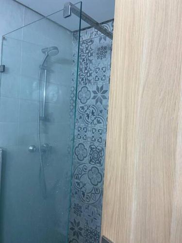 La salle de bains est pourvue d'une douche avec une porte en verre. dans l'établissement Kamal Parc, à Mohammedia
