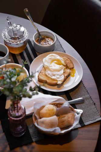 a table with two plates of breakfast food on it at Umani Pousada in Bento Gonçalves