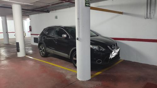 a black car is parked in a garage at Apartamento en el Portil in El Portil