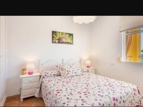 a white bedroom with a bed and a window at Apartamento en el Portil in El Portil