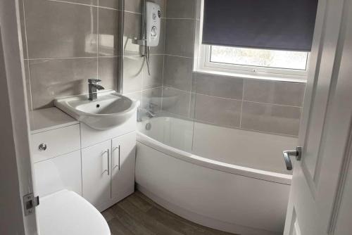 a bathroom with a sink and a tub and a toilet at Campion lodge in Hull