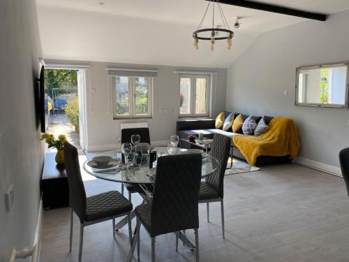 Una sala de estar con una mesa y sillas y un sofá. en The Terrace - Annexe with views, en Bathford