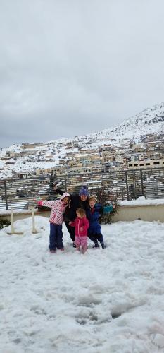 a group of three children standing in the snow at Snow View Suite סוויטת סנו וויו in Majdal Shams