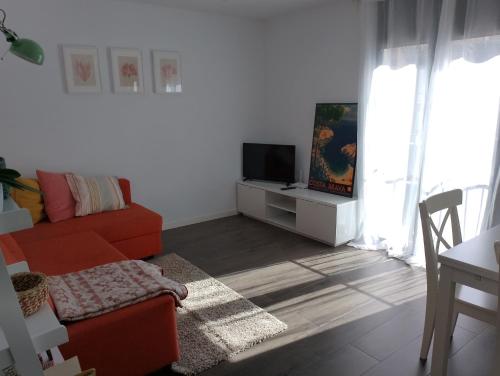 a living room with a red couch and a tv at Pis pràctic i agradable sobre la Marina Palamós in Palamós