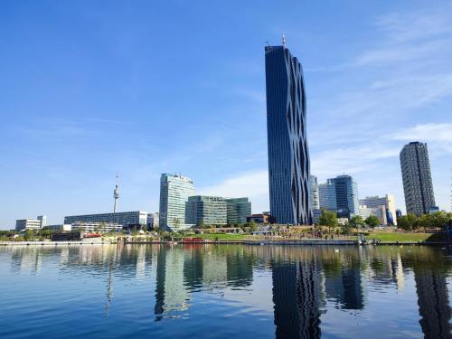 un perfil urbano con un edificio alto y un cuerpo de agua en CENTER ! 2 stops from the City Center!, en Viena