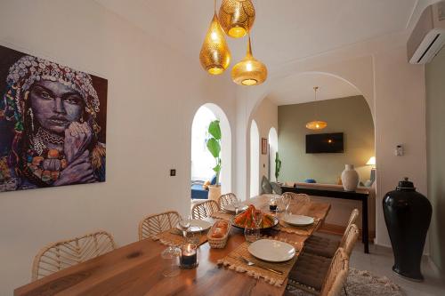 a dining room with a wooden table and a painting on the wall at RIAD JULILU PRIVATISE in Marrakech