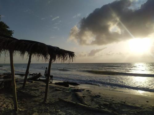 a beach with an umbrella and the ocean at Cielito Lindo in Necoclí