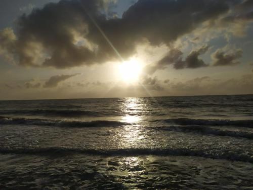 a sunset over the ocean with the sun in the sky at Cielito Lindo in Necoclí
