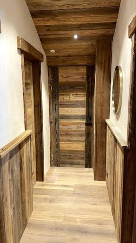 an empty hallway with wooden floors and wooden walls at Top floor appartment, ski in ski out, superb view in La Daille