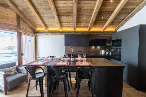 a kitchen with a large black island in a room at Top floor appartment, ski in ski out, superb view in La Daille