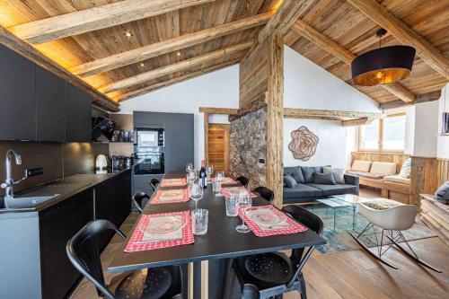 a kitchen and living room with a table with chairs at Top floor appartment, ski in ski out, superb view in La Daille