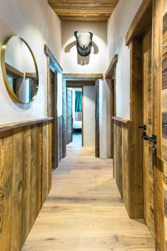 a hallway with wooden doors and a mirror at Top floor appartment, ski in ski out, superb view in La Daille