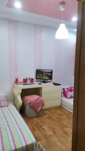 ein Schlafzimmer mit einem Schreibtisch und einem Bett darin in der Unterkunft Appartement en centre de ville in El Aaiún