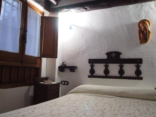 a bedroom with a bed and a white wall at Posá la Cestería in Baños de la Encina