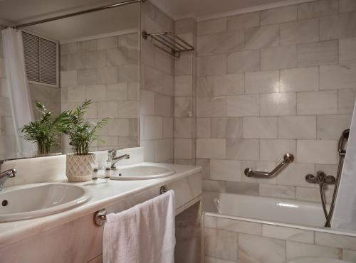 a bathroom with a tub and a sink and a tubermott at Strada Marina Hotel in Zakynthos Town