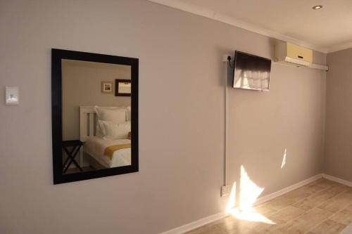 ein Spiegel an einer Wand in einem Zimmer mit einem Bett in der Unterkunft Winter Hill Home - Familia in East London