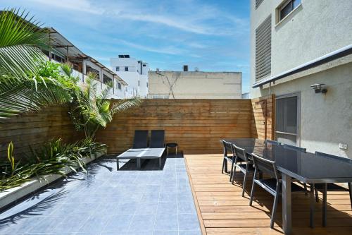 a patio with a table and chairs on a building at Escapade by HolyGuest in Tel Aviv