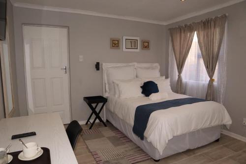 ein Schlafzimmer mit einem weißen Bett und einem Fenster in der Unterkunft Winter Hill Home - Familia in East London