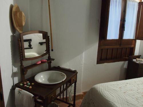 a bathroom with a mirror and a wooden chair at Posá la Cestería in Baños de la Encina