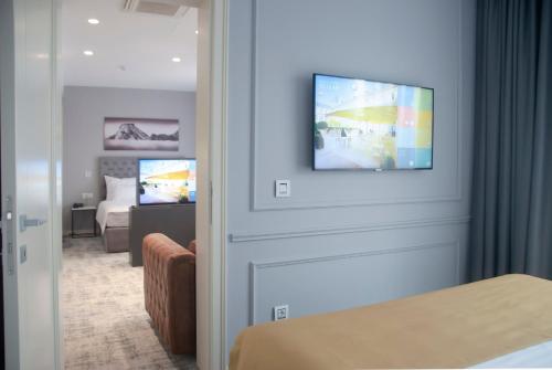 a hotel room with a television hanging on the wall at H41 Luxury Suites in Belgrade