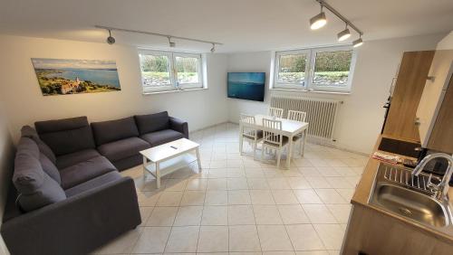 a living room with a couch and a table at Komfortable & moderne Ferienwohnung in Markdorf - Familie Hildebrand in Markdorf