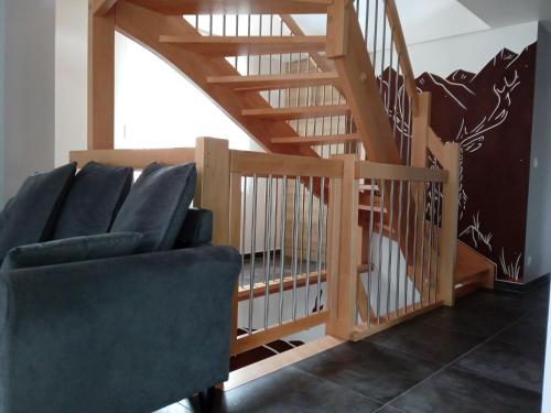 a living room with a staircase and a chair at Le gîte des Kritter in Stosswihr