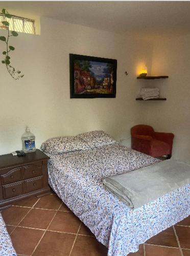 a bedroom with a bed and a dresser and a picture on the wall at Quinta Calandria Haus in Cancún