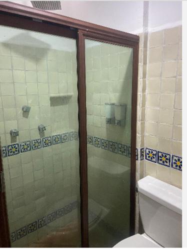 a bathroom with a glass shower with a toilet at Quinta Calandria Haus in Cancún