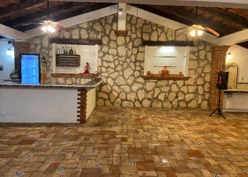 a large room with a stone wall and a counter at Quinta Calandria Haus in Cancún