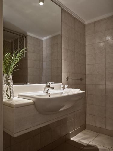 a bathroom with a sink and a bath tub at Strada Marina Hotel in Zakynthos Town