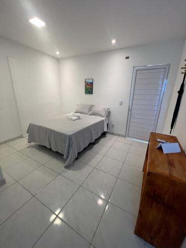 a bedroom with a bed and a wooden table at POUSADA CENÁRIO IDEAL in Icapuí