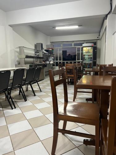 un comedor con mesas y sillas en un restaurante en Premium Center Hotel, en Betim