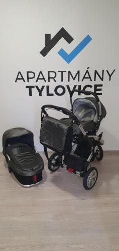a stroller and suitcase sitting in front of a sign at Apartmány Tylovice in Rožnov pod Radhoštěm
