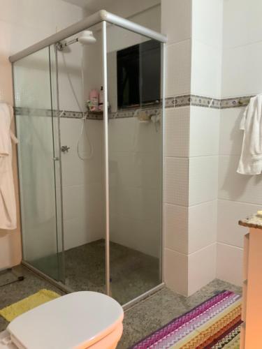 y baño con cabina de ducha y aseo. en Lindo apartamento em Caxambu, en Caxambu