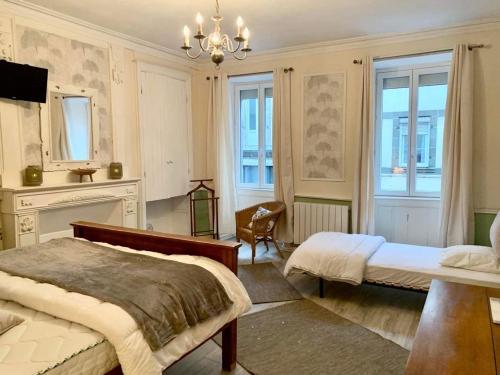 a bedroom with two beds and a chandelier at The LightHouse Chambres à louer in Châteaulin