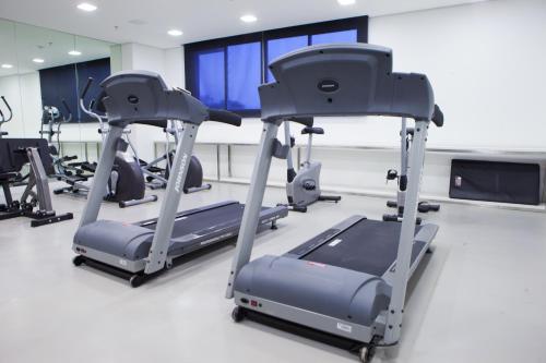 a gym with several tread machines in a room at Intercity Brasilia Led Aguas Claras in Brasilia