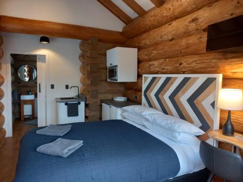 a bedroom with a blue bed in a log cabin at The Cabin in Twizel