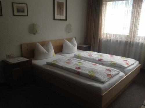 a bedroom with two beds and a window at Ferienwohnung Blumen Penz in Zell am Ziller