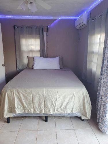 a bedroom with a bed with purple lights on it at StarFish Apartment in Six Huts