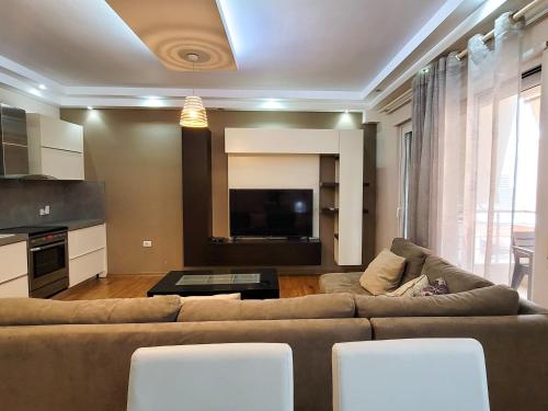 uma sala de estar com um sofá e uma televisão em Quiet Apartment near Tirana Lake em Tirana