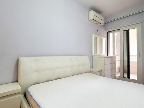 um quarto branco com uma cama e uma janela em Quiet Apartment near Tirana Lake em Tirana
