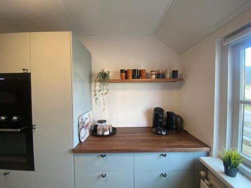 a kitchen with white cabinets and a wooden counter top at Noorderzon in Buren