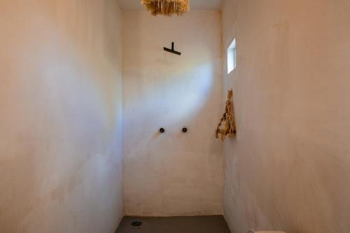 a bathroom with a white wall and a window at Casa OM Chakra in Brisas de Zicatela