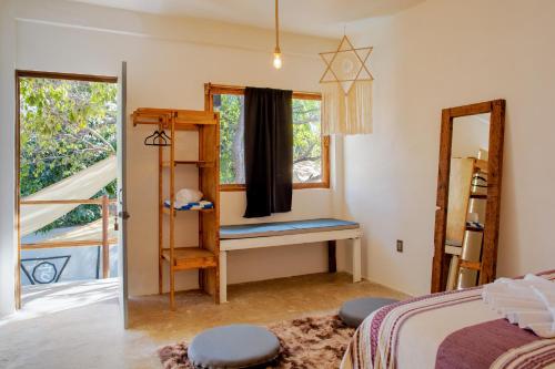 a bedroom with a bed and a mirror and a window at Casa OM Chakra in Brisas de Zicatela