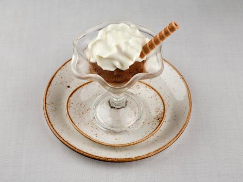 a chocolate dessert with whipped cream on a plate at O Palleiro do Pe do Forno in Orellán