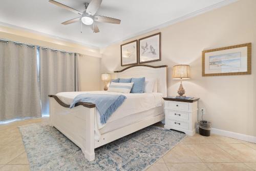 a bedroom with a white bed and a ceiling fan at Shipwatch B101 in Perdido Key