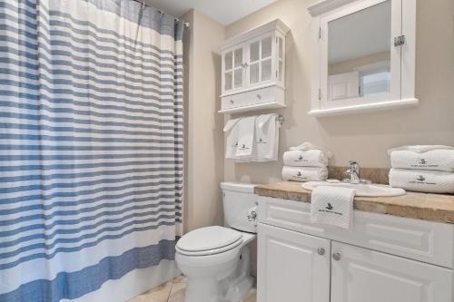 a bathroom with a toilet and a shower curtain at Shipwatch B101 in Perdido Key