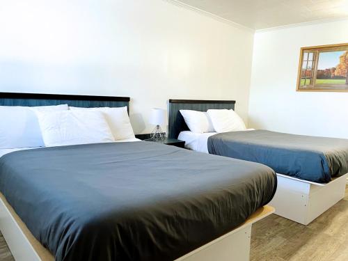 2 Betten in einem Zimmer mit 2 Betten sidx sidx sidx sidx in der Unterkunft Motel Moreau in Saint-Félicien